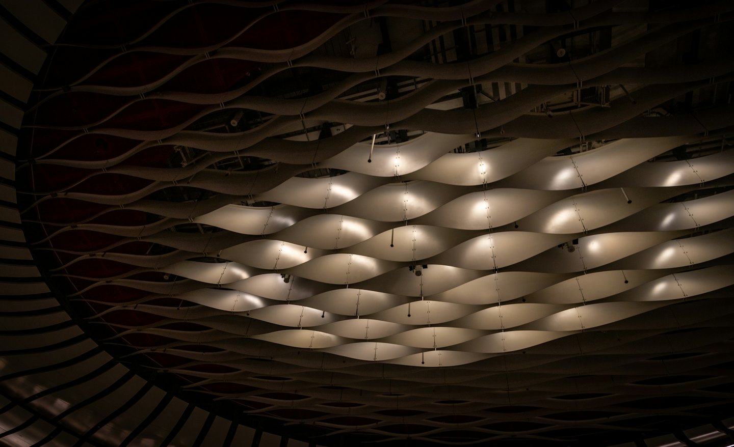 Soffitto moderno con pannelli acustici ondulati e illuminazione a incasso.